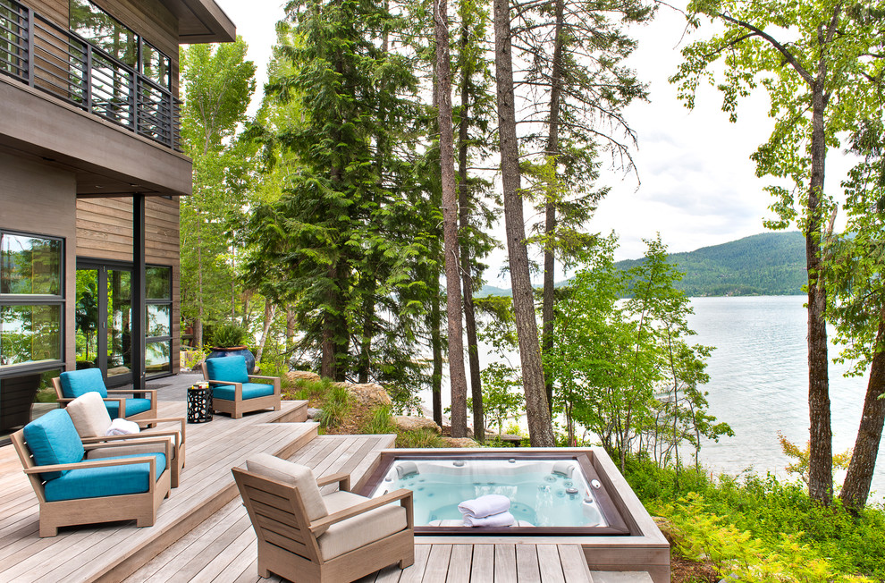 Cette photo montre une piscine arrière montagne rectangle avec un bain bouillonnant et une terrasse en bois.
