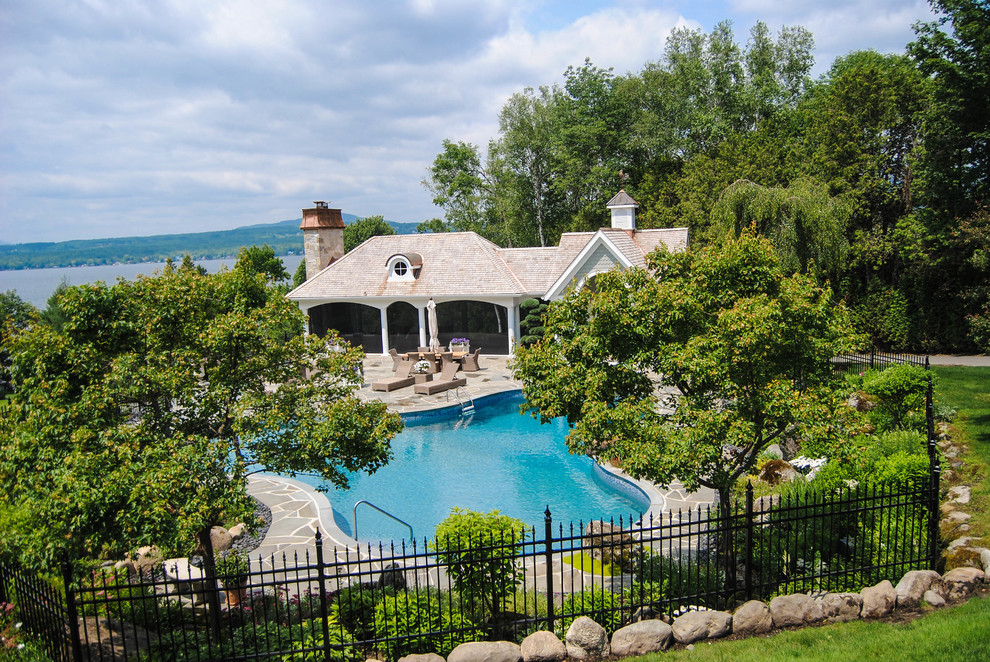 Example of a large arts and crafts backyard stone and custom-shaped pool design in Montreal