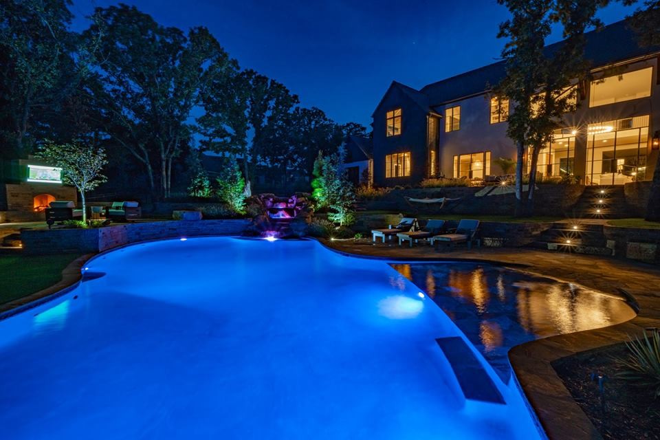 Esempio di una grande piscina naturale tradizionale personalizzata dietro casa con pavimentazioni in pietra naturale