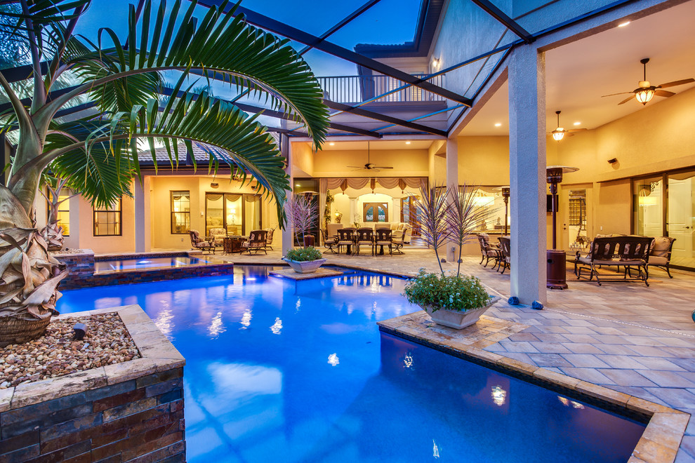 Esempio di una piscina chic personalizzata di medie dimensioni e dietro casa con una vasca idromassaggio e piastrelle