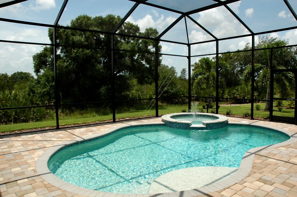 Inspiration for a mid-sized transitional backyard concrete paver and custom-shaped hot tub remodel in Tampa