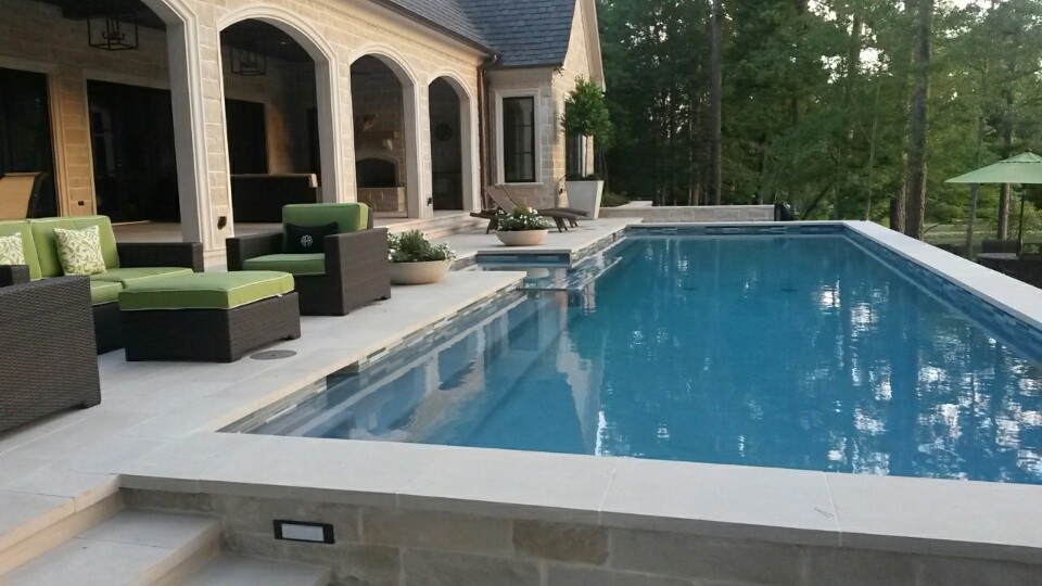 Imagen de piscinas y jacuzzis alargados clásicos renovados grandes rectangulares en patio trasero con adoquines de hormigón
