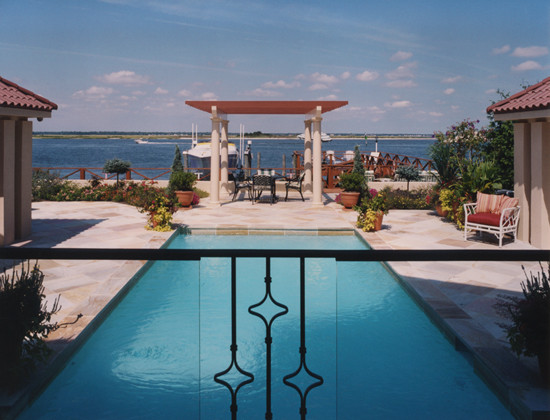 Modelo de casa de la piscina y piscina alargada mediterránea de tamaño medio rectangular en patio trasero con suelo de baldosas