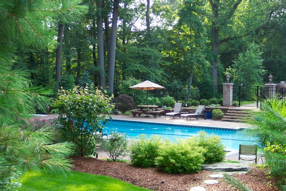 Immagine di una grande piscina monocorsia tradizionale rettangolare dietro casa con una vasca idromassaggio e pavimentazioni in mattoni