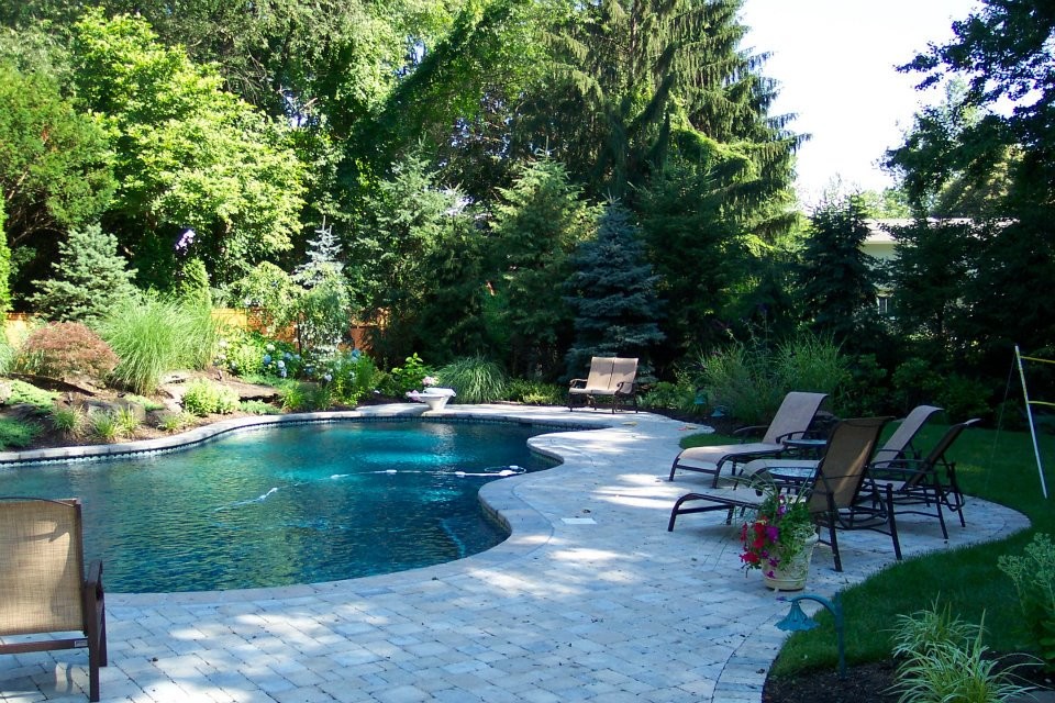 Foto di una grande piscina personalizzata dietro casa con pavimentazioni in mattoni