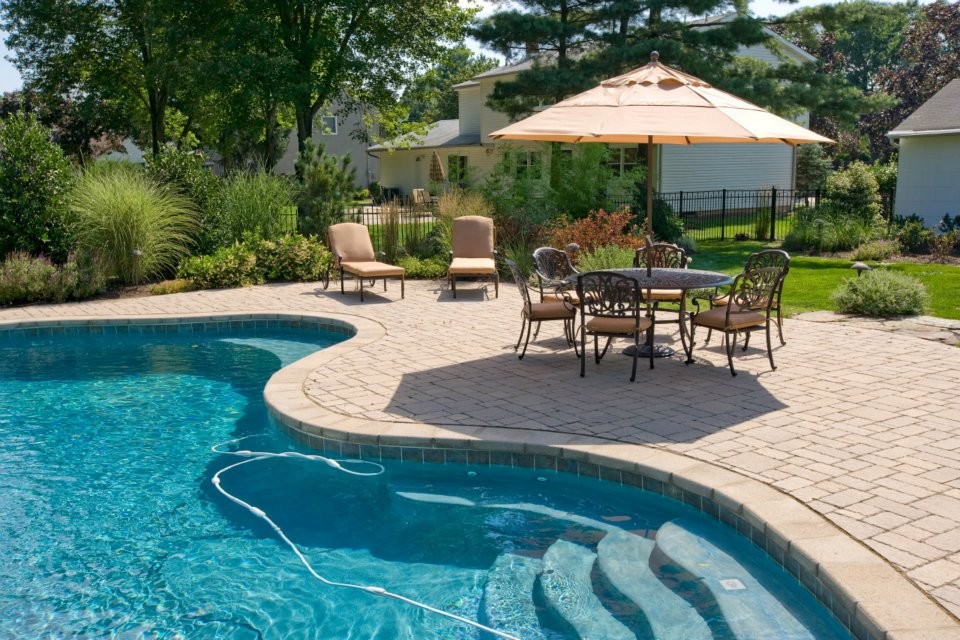 Imagen de piscina con fuente natural rural extra grande a medida en patio trasero con adoquines de ladrillo
