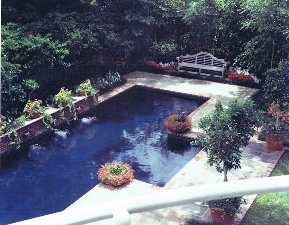 Foto de piscina con fuente natural retro grande a medida en patio trasero con adoquines de ladrillo