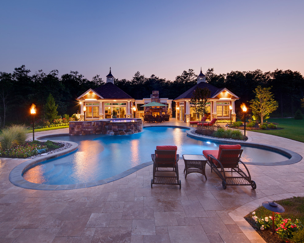 Ejemplo de piscinas y jacuzzis tradicionales renovados grandes a medida en patio trasero con adoquines de piedra natural