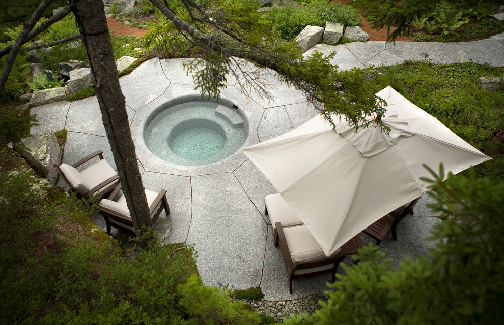 Aménagement d'une piscine arrière montagne de taille moyenne et ronde avec un bain bouillonnant et des pavés en pierre naturelle.