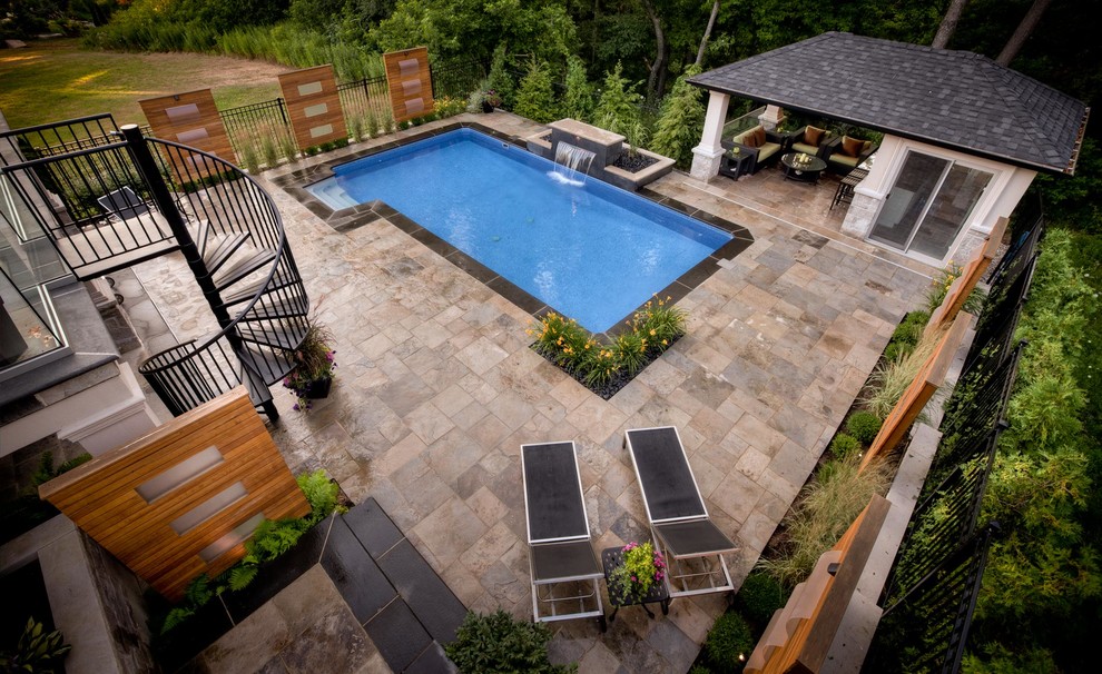 Imagen de piscina clásica renovada de tamaño medio rectangular en patio trasero con adoquines de piedra natural