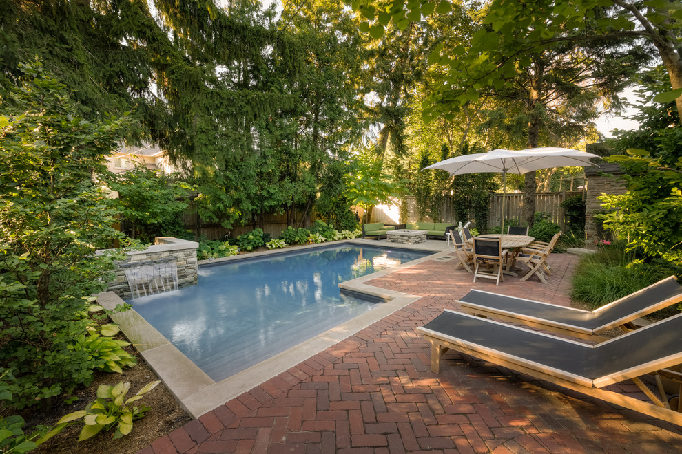 На фото: бассейн на заднем дворе в классическом стиле с фонтаном с