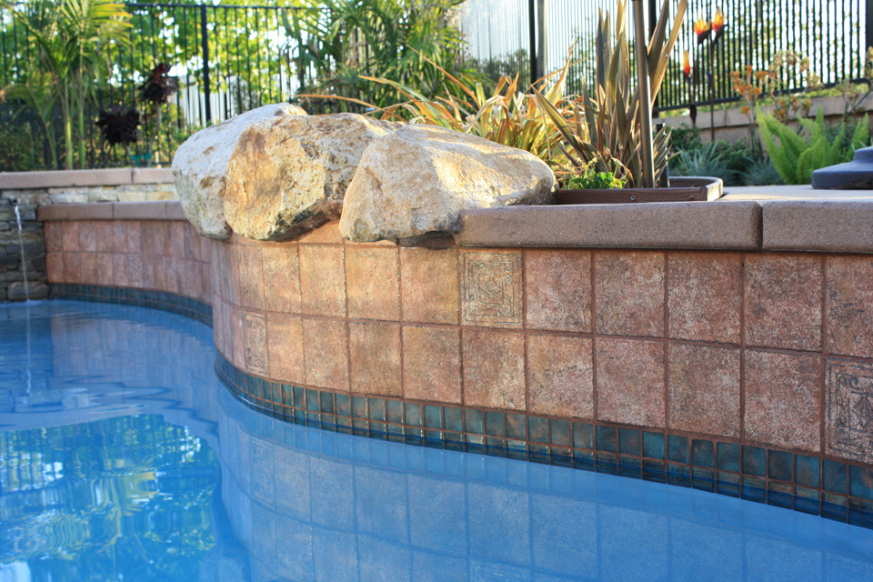 This is an example of a large mediterranean back custom shaped natural hot tub in San Diego with stamped concrete.