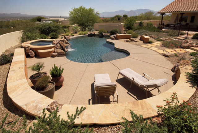 Cette photo montre une piscine arrière sud-ouest américain de taille moyenne et sur mesure avec un bain bouillonnant et une dalle de béton.