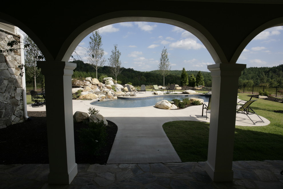 Idee per una piscina naturale stile rurale personalizzata di medie dimensioni e dietro casa con fontane e pavimentazioni in pietra naturale