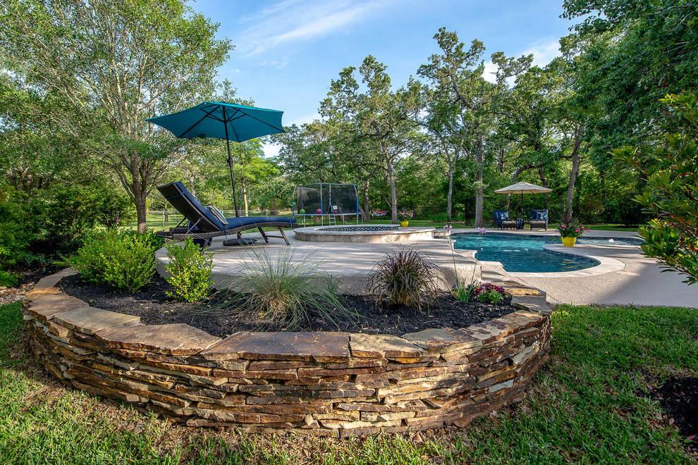 Foto de piscinas y jacuzzis naturales tropicales de tamaño medio a medida en patio trasero con entablado