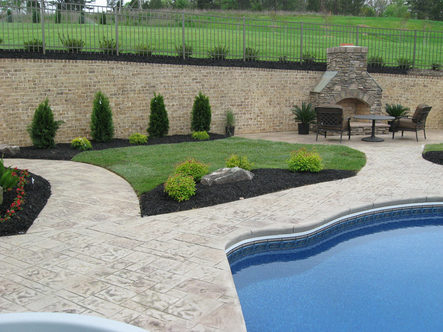 Diseño de piscina alargada clásica grande a medida en patio trasero con adoquines de piedra natural