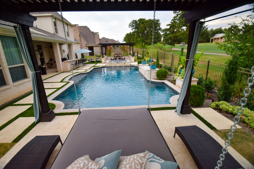 Ejemplo de piscina con fuente alargada actual de tamaño medio a medida en patio trasero con adoquines de piedra natural