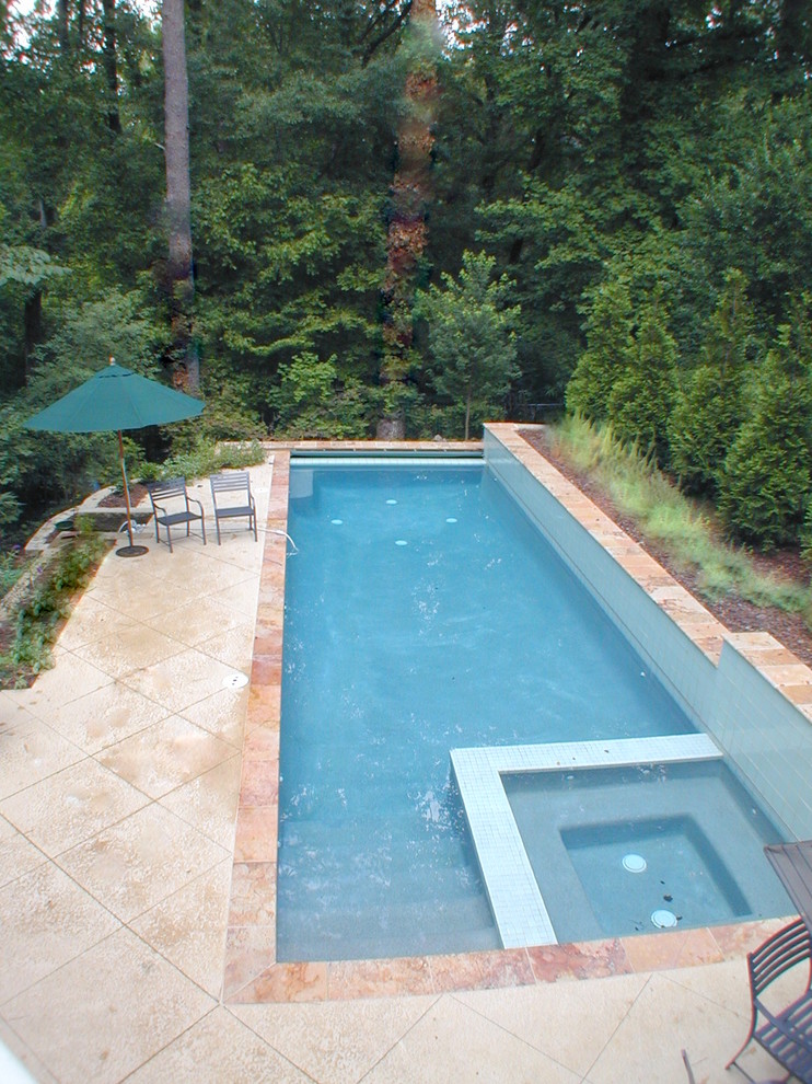 Foto di una piscina monocorsia boho chic rettangolare di medie dimensioni e dietro casa con pavimentazioni in cemento e una vasca idromassaggio
