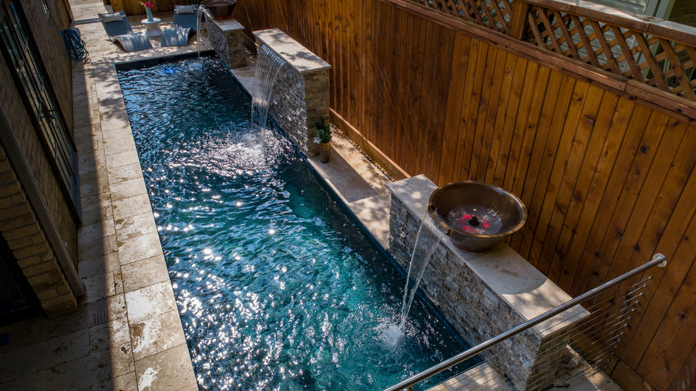 Imagen de piscina con fuente alargada minimalista pequeña rectangular en patio trasero con adoquines de piedra natural
