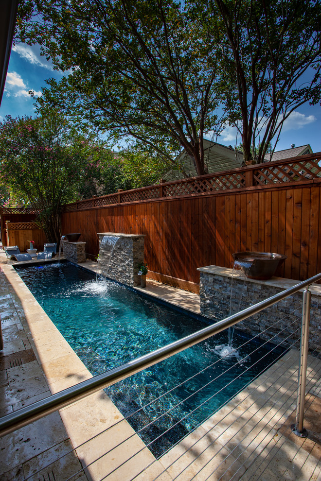 Immagine di una piccola piscina monocorsia minimalista rettangolare dietro casa con fontane e pavimentazioni in pietra naturale