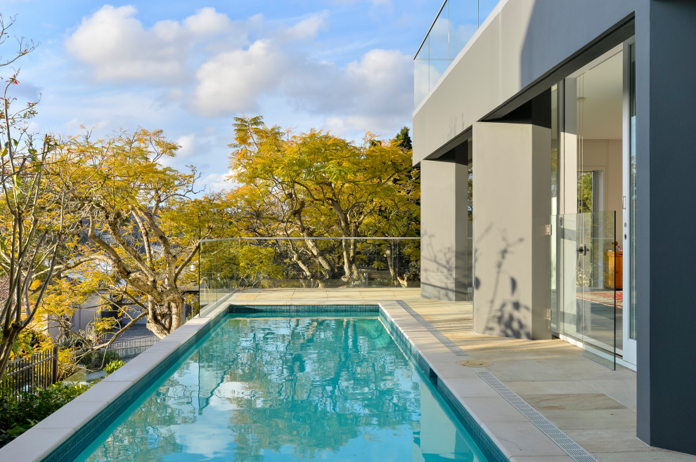 Idee per una piscina monocorsia contemporanea rettangolare nel cortile laterale con pavimentazioni in pietra naturale