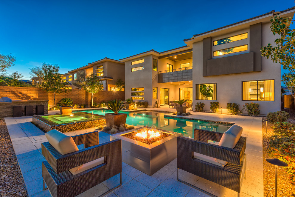 Example of a large island style backyard stone and rectangular lap hot tub design in Las Vegas