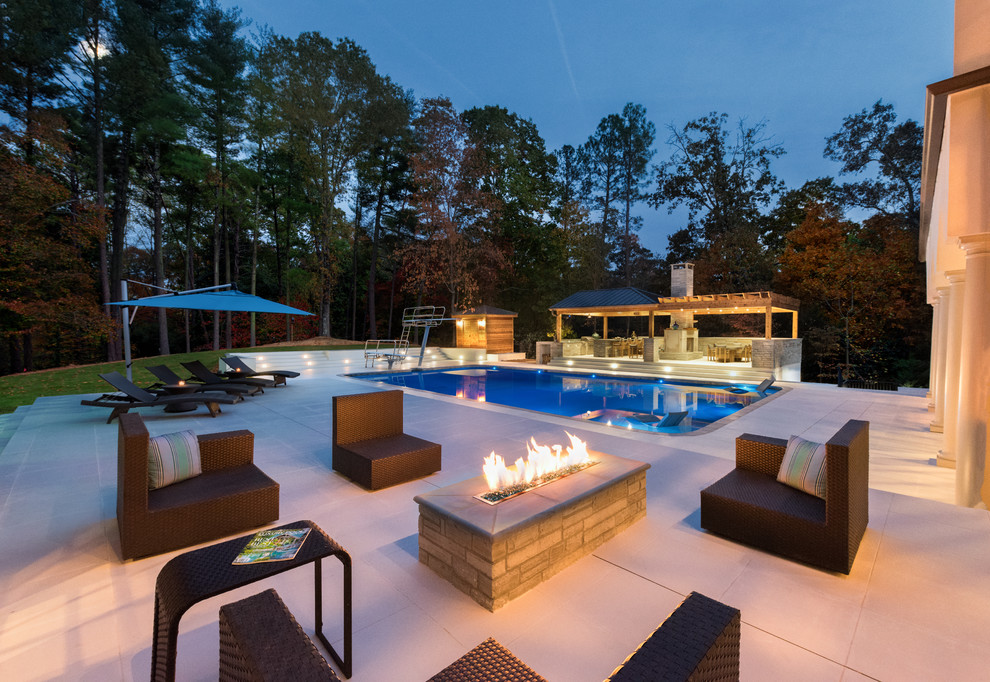 Imagen de casa de la piscina y piscina actual grande rectangular con suelo de baldosas