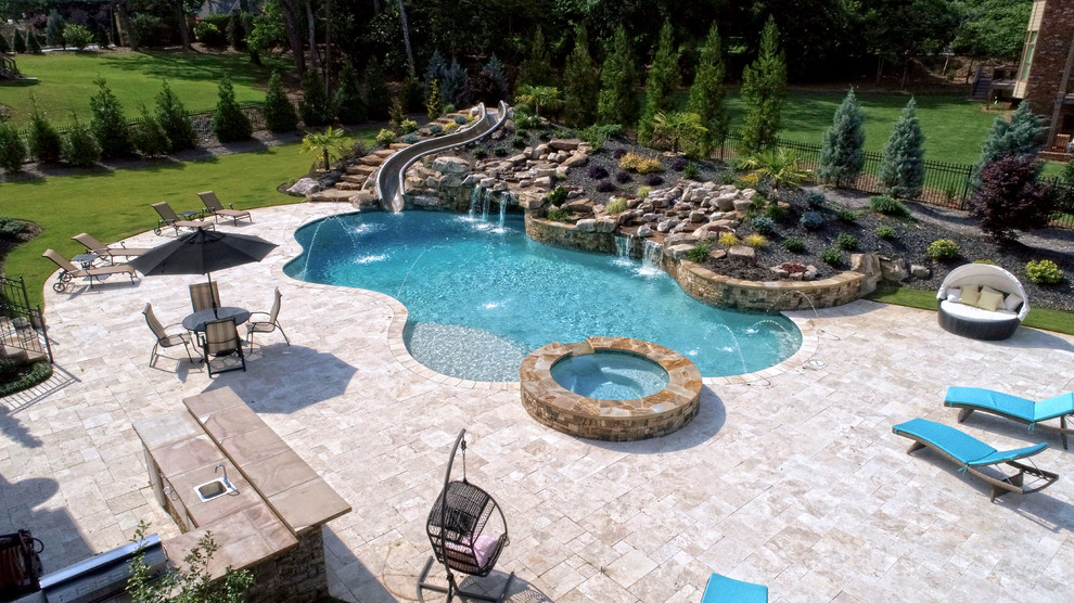 Ispirazione per una grande piscina naturale personalizzata dietro casa con un acquascivolo e pedane