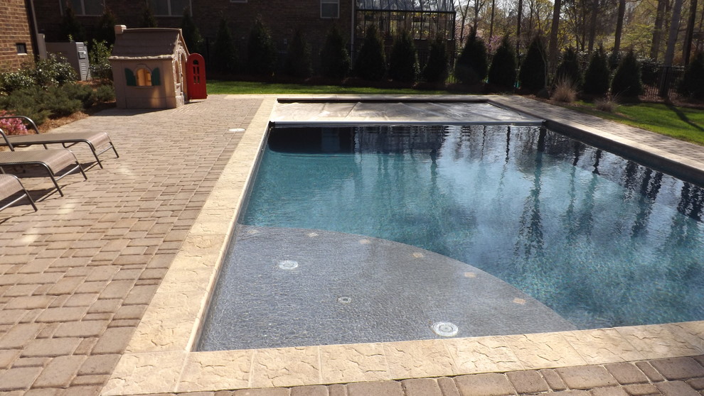 Стильный дизайн: большой спортивный, прямоугольный бассейн на заднем дворе в стиле неоклассика (современная классика) с фонтаном и мощением клинкерной брусчаткой - последний тренд
