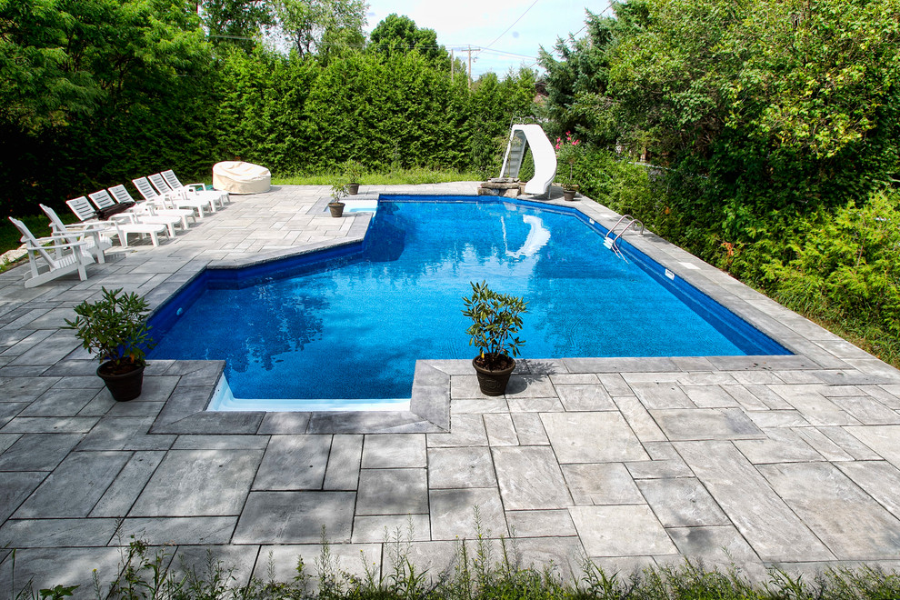 Idéer för att renovera en funkis anpassad pool på baksidan av huset, med vattenrutschkana och kakelplattor
