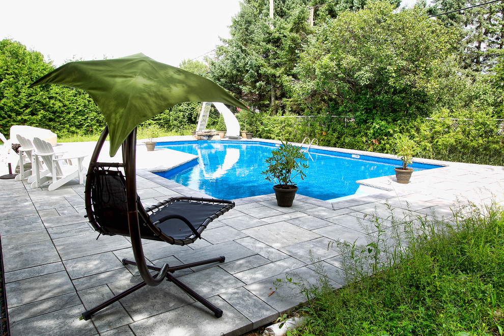 Diseño de piscina con tobogán contemporánea grande a medida en patio trasero con suelo de baldosas