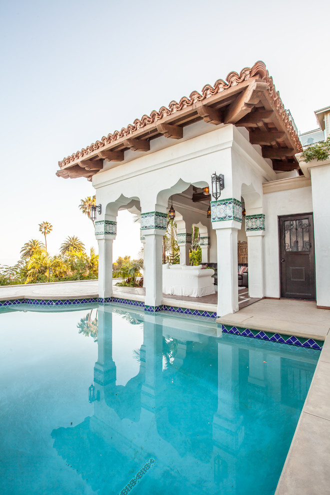 Esempio di una grande piscina monocorsia mediterranea personalizzata dietro casa con cemento stampato e una vasca idromassaggio