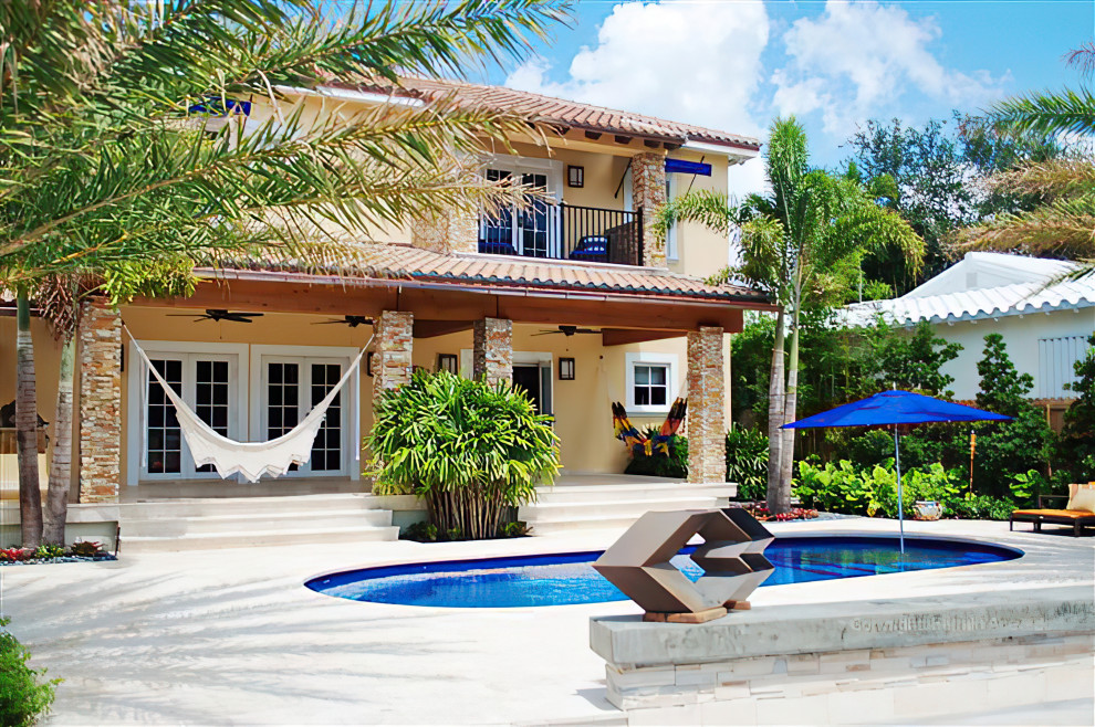 Mittelgroßes Mediterranes Sportbecken hinter dem Haus in individueller Form mit Natursteinplatten in Miami