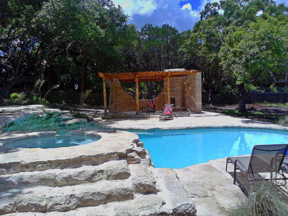 Großer Mediterraner Pool hinter dem Haus in Nierenform mit Natursteinplatten in Austin