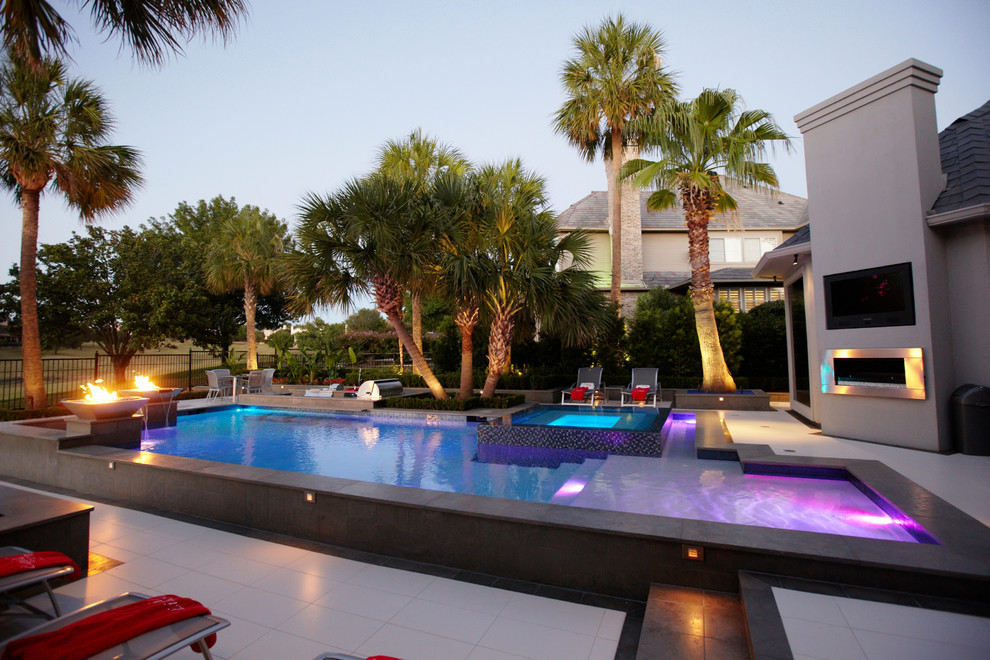 Foto di una piscina design personalizzata di medie dimensioni e dietro casa con fontane e piastrelle