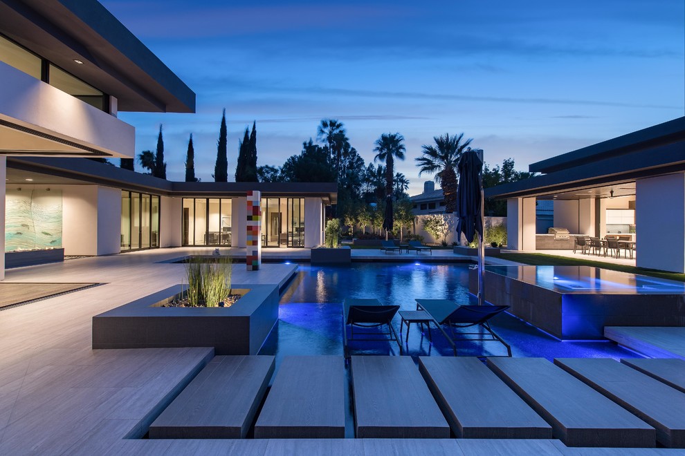 Esempio di una grande piscina monocorsia moderna personalizzata dietro casa con piastrelle e una vasca idromassaggio