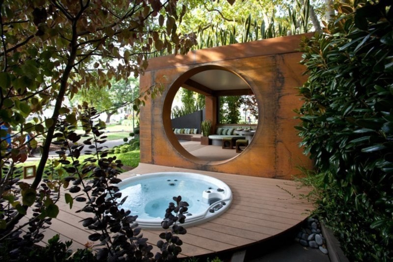 Modelo de piscina con fuente bohemia de tamaño medio redondeada en patio trasero