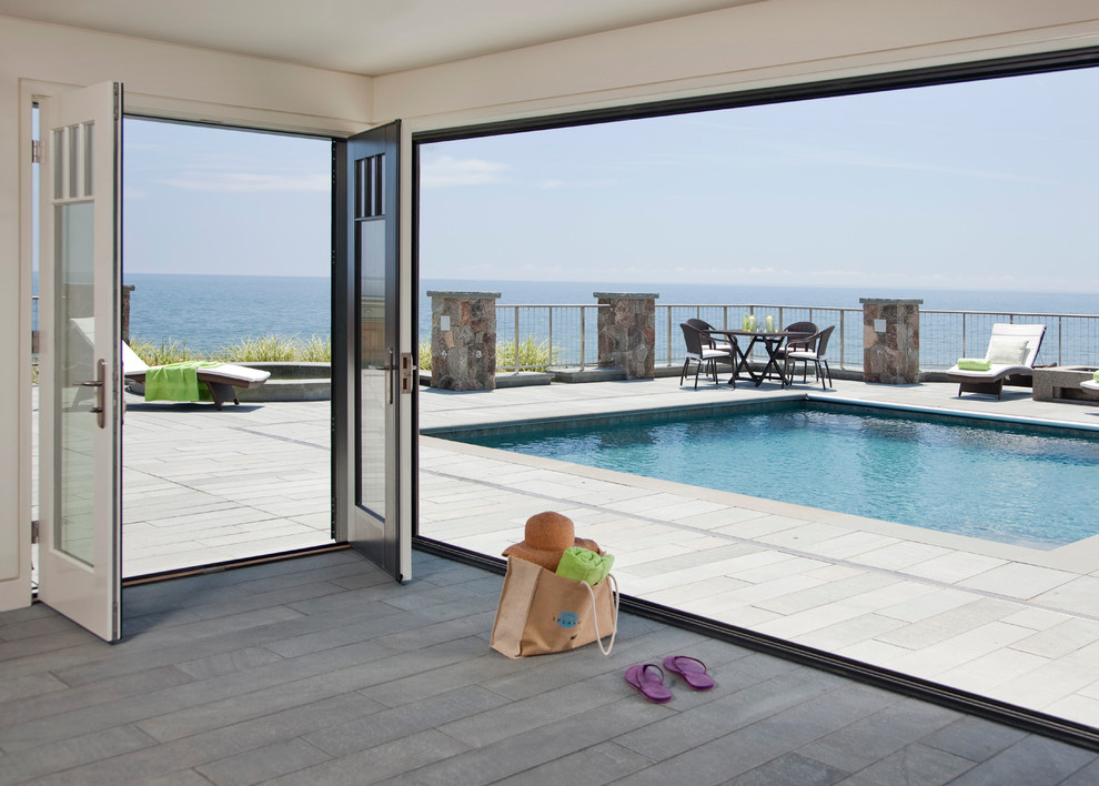 Example of a large trendy backyard stone and rectangular pool design in Boston