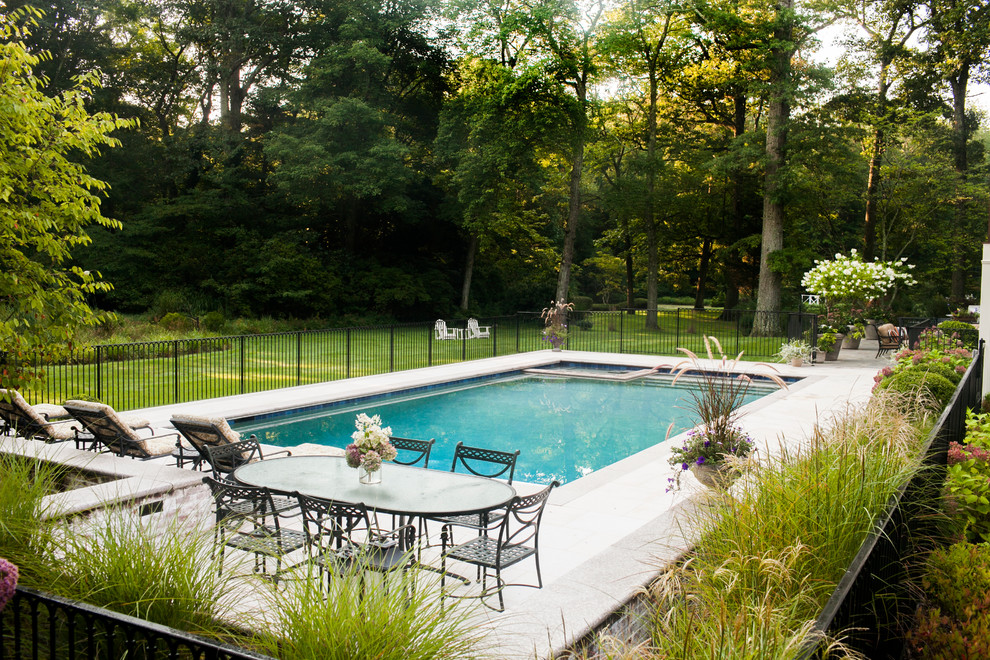 Foto di una piscina monocorsia classica rettangolare di medie dimensioni e dietro casa con pavimentazioni in cemento