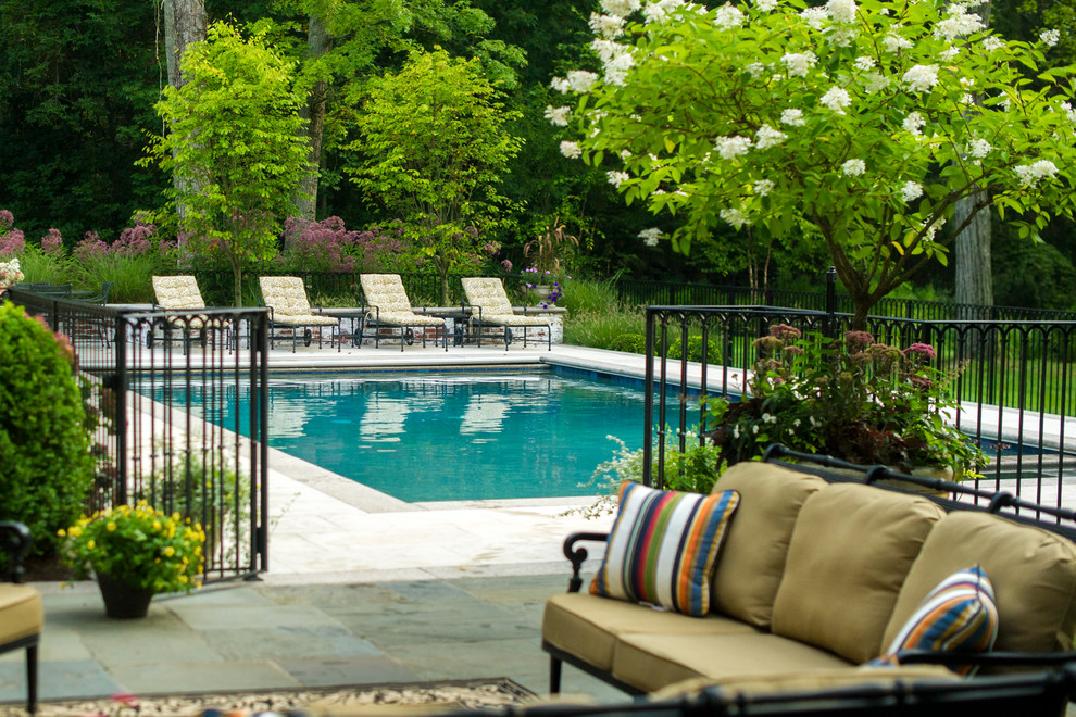 Идея дизайна: прямоугольный бассейн среднего размера на заднем дворе в классическом стиле с покрытием из каменной брусчатки и забором