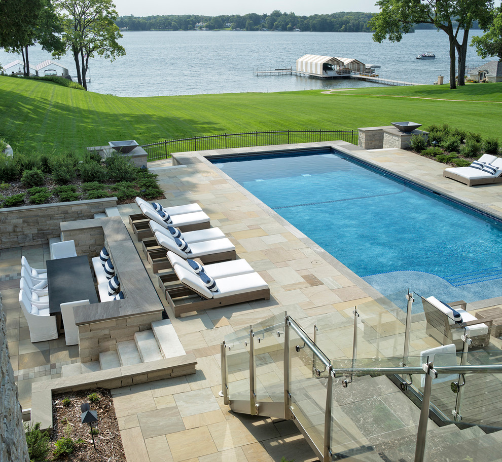 Foto de piscina contemporánea extra grande rectangular en patio trasero con adoquines de piedra natural