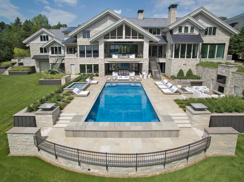 Источник вдохновения для домашнего уюта: огромный прямоугольный бассейн на заднем дворе в современном стиле с покрытием из каменной брусчатки
