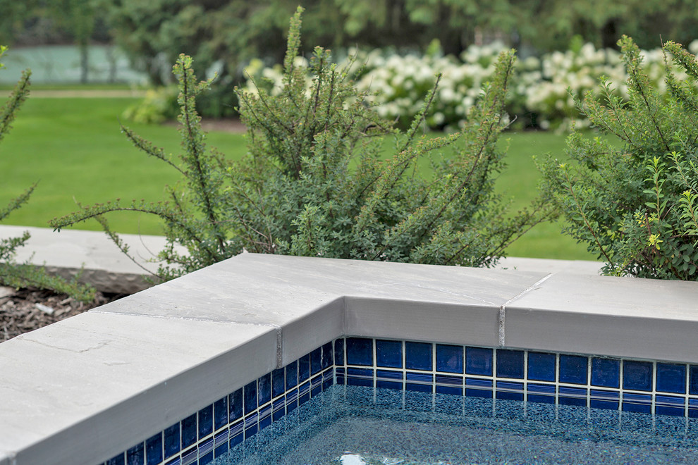 Foto di un'ampia piscina contemporanea rettangolare dietro casa con pavimentazioni in pietra naturale