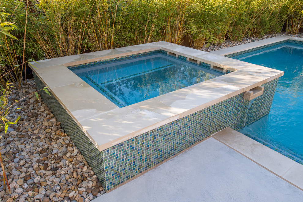 This is an example of a small contemporary back hot tub in Dallas with concrete slabs.