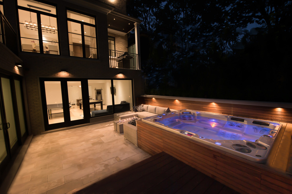 Ispirazione per una grande piscina fuori terra moderna rettangolare dietro casa con una vasca idromassaggio e pedane
