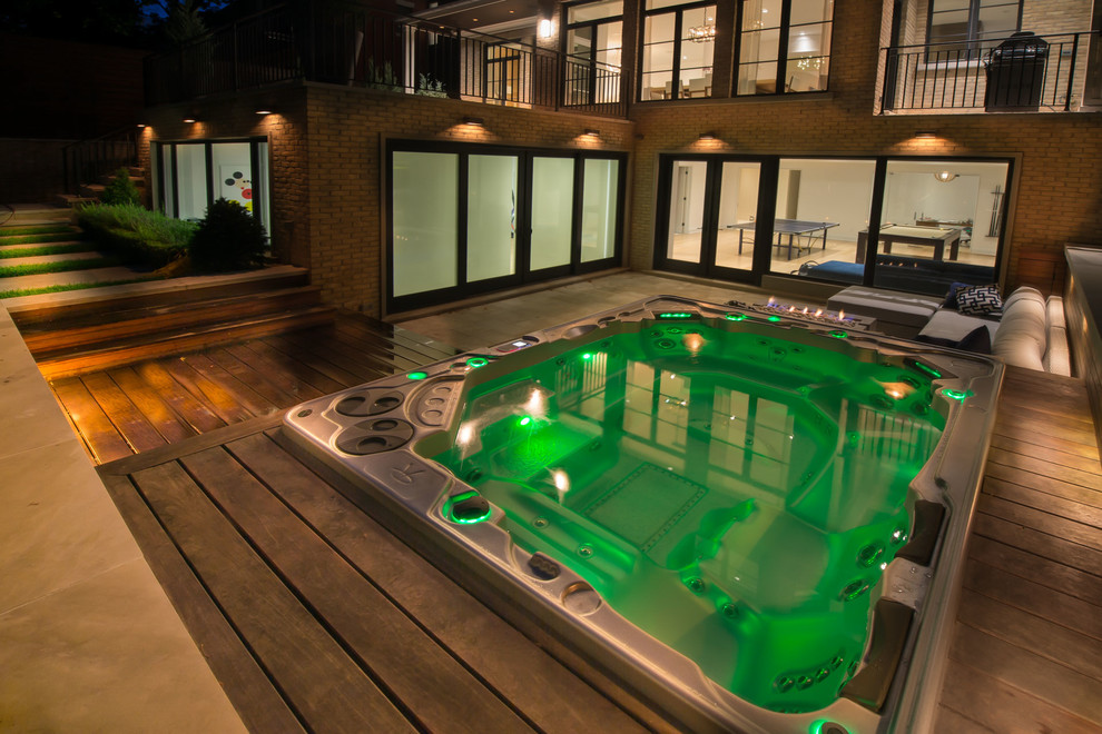 Aménagement d'une grande piscine hors-sol et arrière rétro rectangle avec un bain bouillonnant et une terrasse en bois.