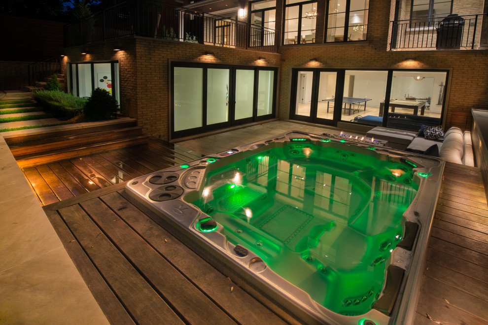 Modelo de piscinas y jacuzzis elevados vintage grandes rectangulares en patio trasero con entablado