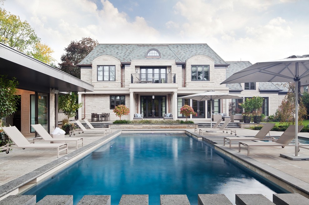 Идея дизайна: прямоугольный бассейн на заднем дворе в классическом стиле с домиком у бассейна и мощением тротуарной плиткой