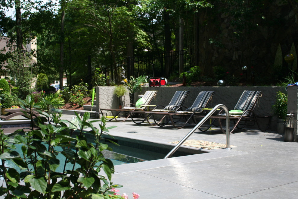 Immagine di una piscina a sfioro infinito minimal rettangolare di medie dimensioni e dietro casa con una dépendance a bordo piscina e pavimentazioni in cemento