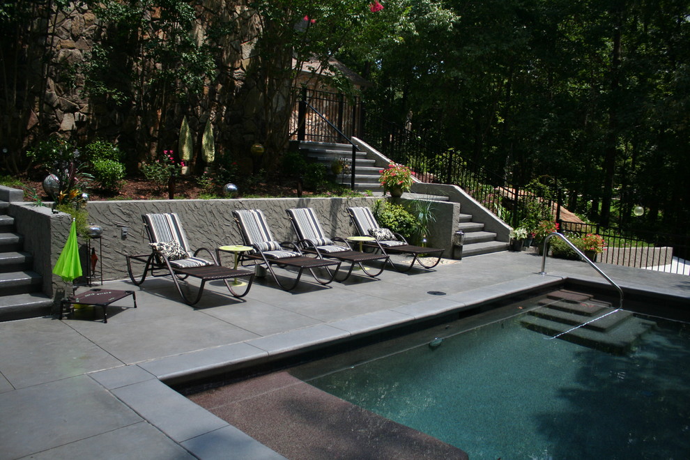Example of a mid-sized trendy backyard concrete paver and rectangular infinity pool house design in Atlanta